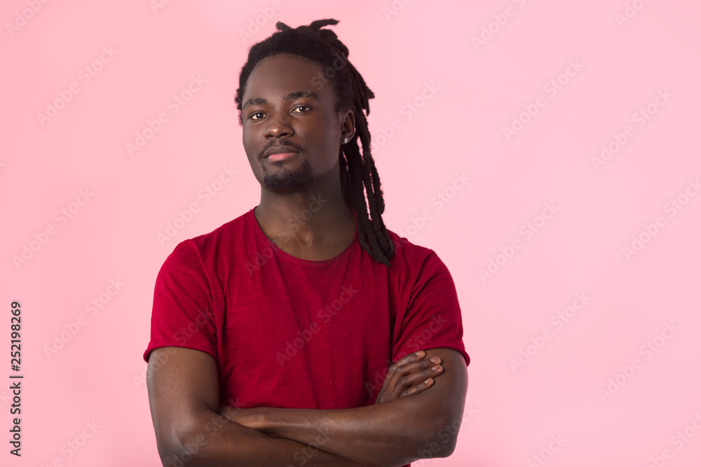 handsome african man with dreadlocks in a red t-shirt on a pink background handsome african man with dreadlocks in a red t-shirt on a pink background