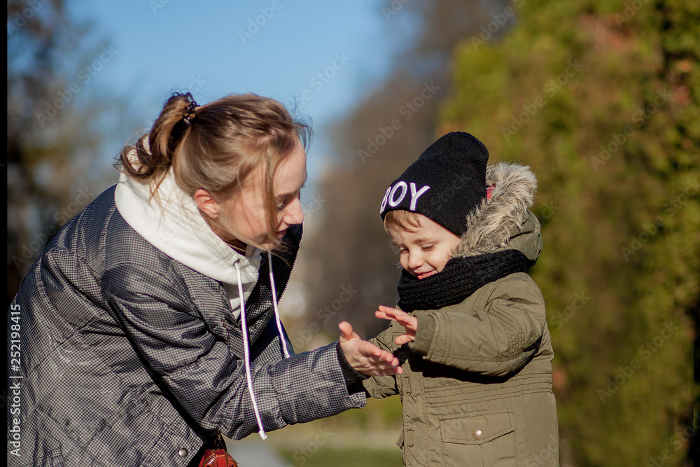 Fototapeta premium Son and mother playing together in the park. Mother's day