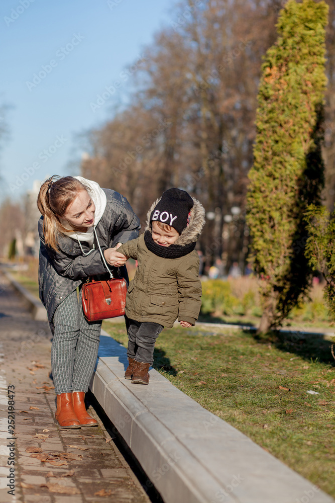 Fototapeta premium Son and mother playing together in the park. Mother's day