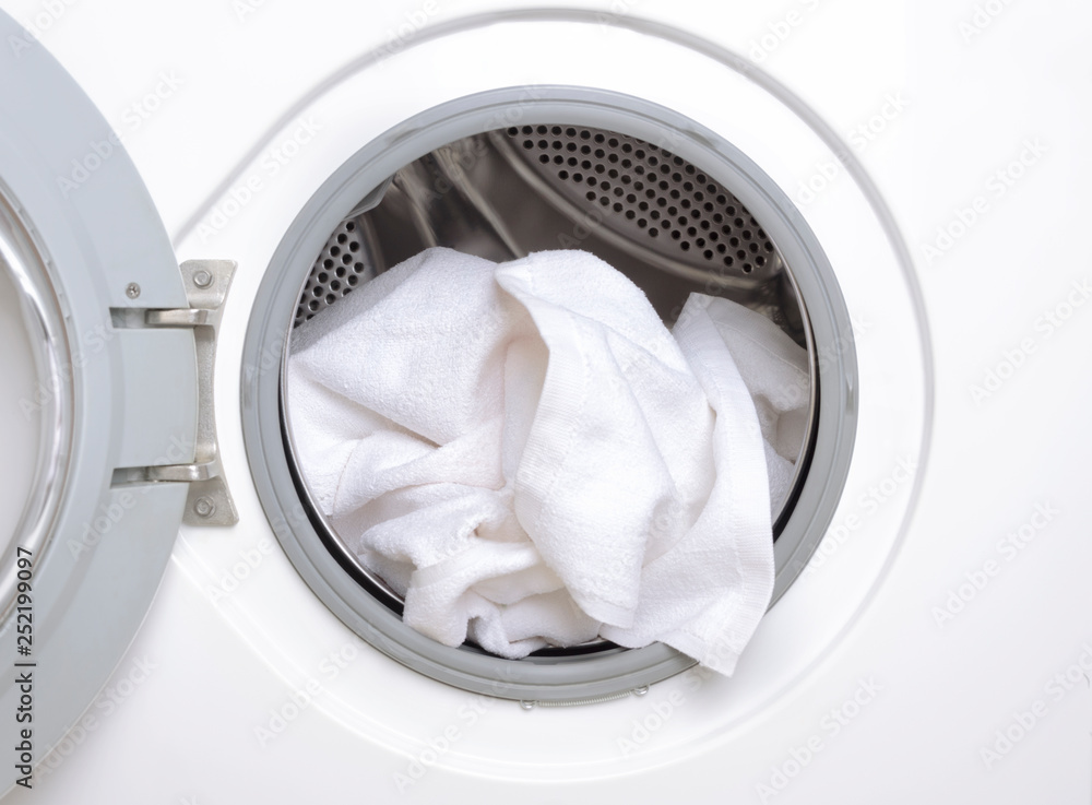 Finishing a part house, washing the white towels.Closeup of washing machine drum Finishing a part house, washing the white towels.Closeup of washing machine drum