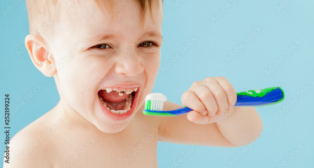 Portrait of little boy with toothbrush on blue background Portrait of little boy with toothbrush on blue background