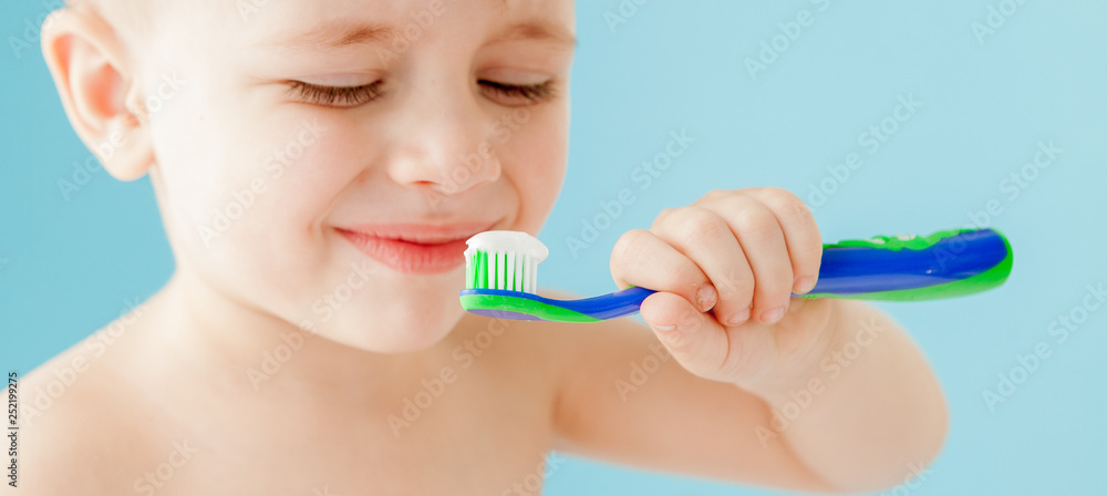 Portrait of little boy with toothbrush on blue background Portrait of little boy with toothbrush on blue background
