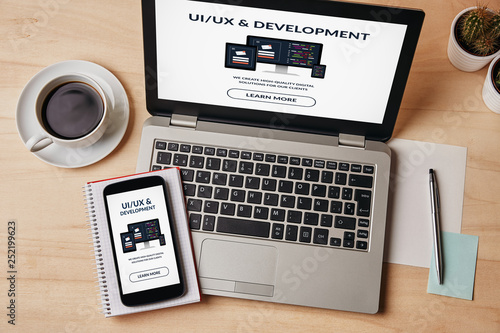 UI/UX design and development concept on laptop and smartphone screen