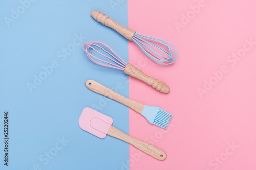 pastel colored whisk, spatula, and pastry brush on a pastel pink and blue background. Minimal style. 