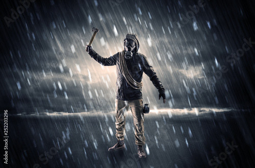 Terrorist in a stormy space with gas mask on his hand and weapons on his arm   © ra2 studio