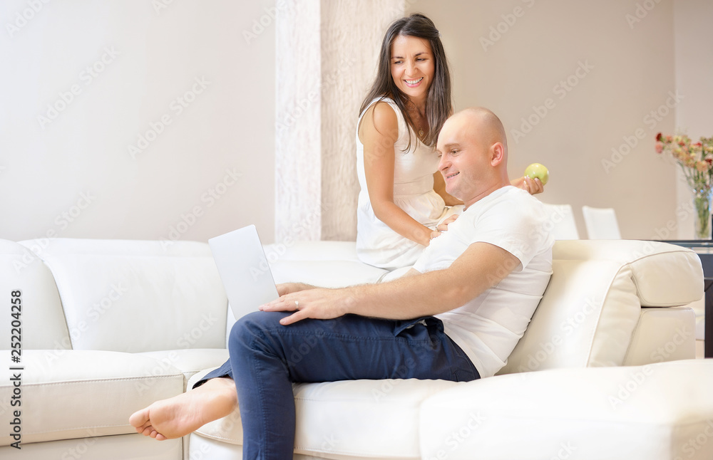 Young couple relaxing on sofa with laptop.Love,happiness,people and fun concept.