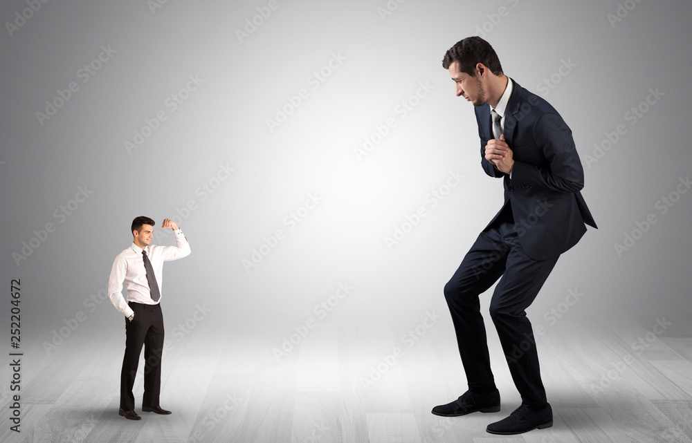 Big debutant young businessman scared of small strong businessman
Big debutant young businessman scared of small strong businessman