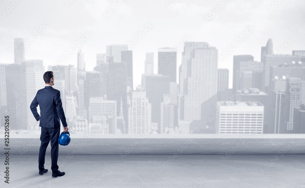 Businessman standing with his back on a roof with objects in his hand
Businessman standing with his back on a roof with objects in his hand