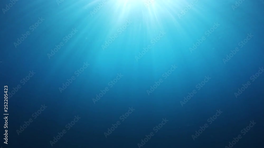 Underwater blue background in sea with sun in ocean Underwater blue background in sea with sun in ocean