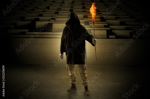 Tablou pe pânză Ugly, aberrant man coming out from the labyrinth with burning flambeau on his ha