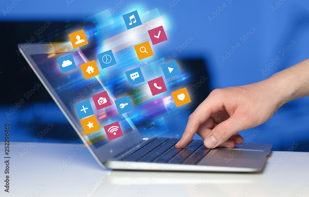 Hand using laptop with colorful fast moving application icons and symbols concept
Hand using laptop with colorful fast moving application icons and symbols concept