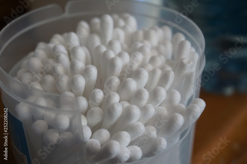 Cotton buds white in a box plastic stick close up in transparent jar medical for makeup and health personal hygiene  photo