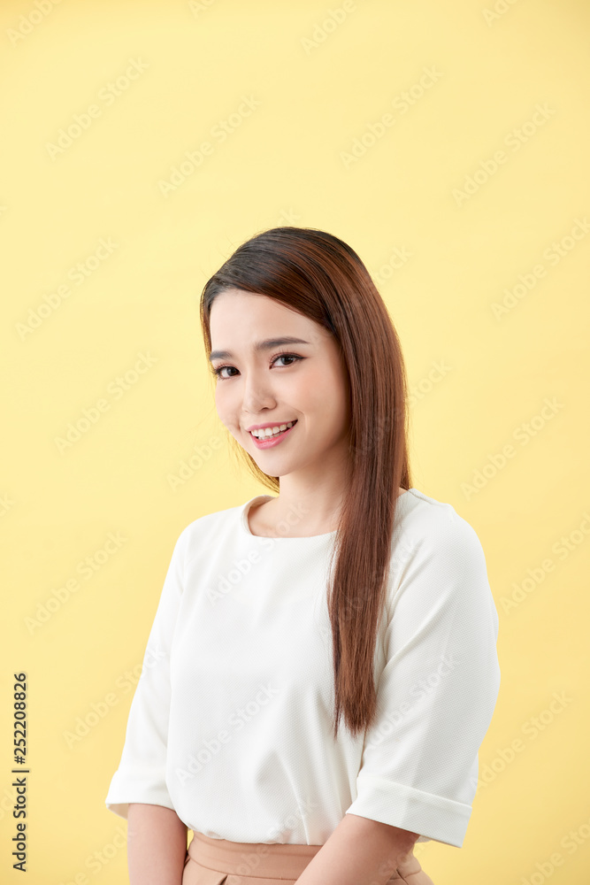 Asian woman smiling with dimple long hair black eyes on yellow background Asian woman smiling with dimple long hair black eyes on yellow background