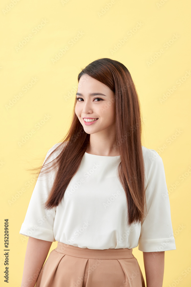 beautiful young woman with long black hair posing on yellow background beautiful young woman with long black hair posing on yellow background
