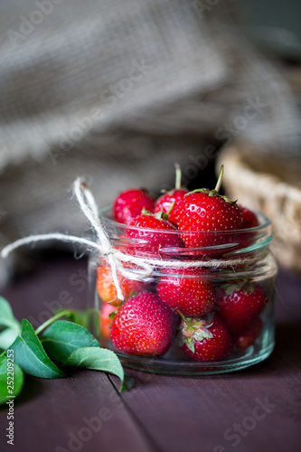 Ripe red strawberries in a glass jar. Delicious summer berries. Healthy food with vitamins for dietary nutrition.