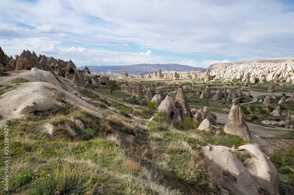 Beautiful panoramic view of the valley with many bizarre rock formations and ancient cave church ruins near Goreme village. Spring day in Cappadocia, Turkey