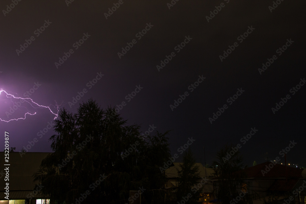 Fototapeta premium Lightning in the night sky over the houses