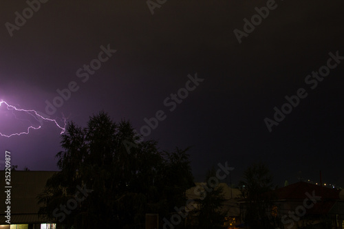 Lightning in the night sky over the houses