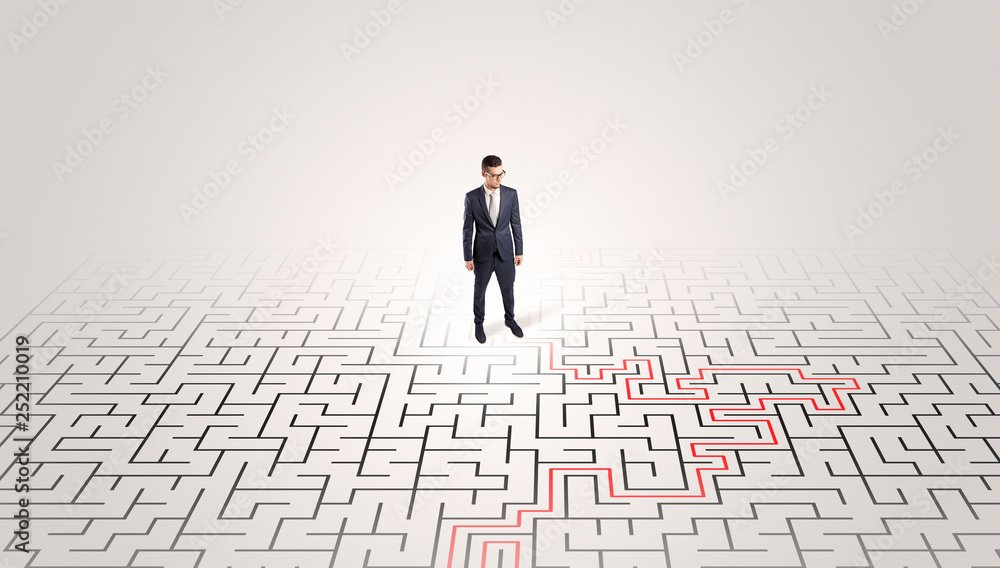 Young entrepreneur standing in a middle of a labyrinth with the solution
Young entrepreneur standing in a middle of a labyrinth with the solution