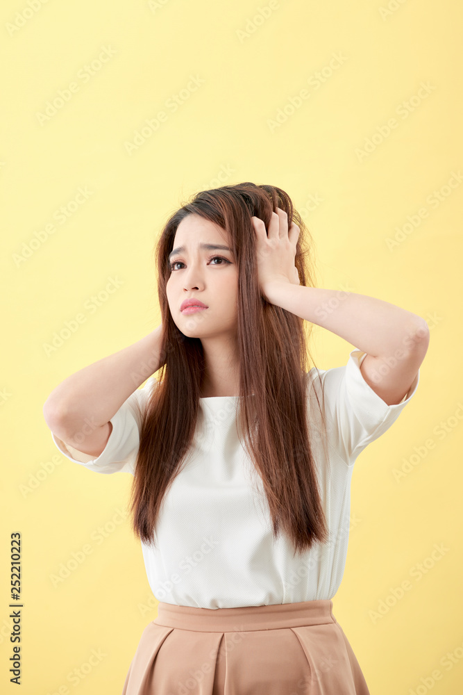 Young asian woman brushing her hair and disappointing condition her hair