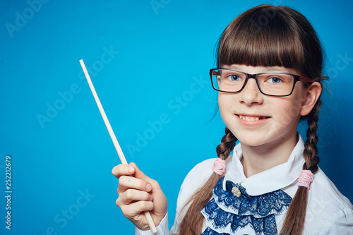 schoolgirl with glasses and a pointer on a blue background