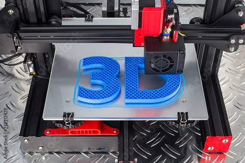 Red black 3D printer printing blue logo symbol on metal diamond plate future technology modern concept photo