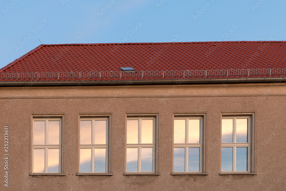 several windows on a house wall in sunny weather several windows on a house wall in sunny weather