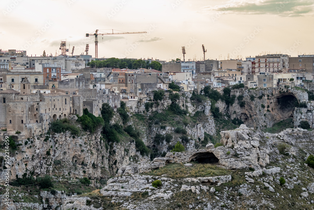 Amazing distant soft colors view of ancient town of Matera, the Sassi di Matera, Basilicata, Southern Italy, cloudy summer afternoon just before sunset