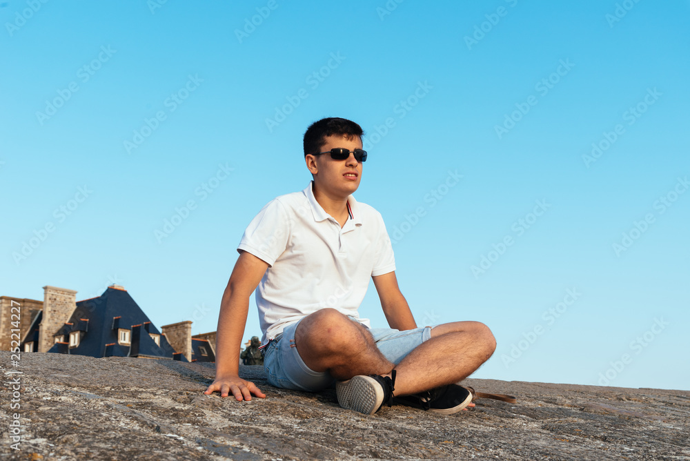 Portrait of young man sitting on the walls