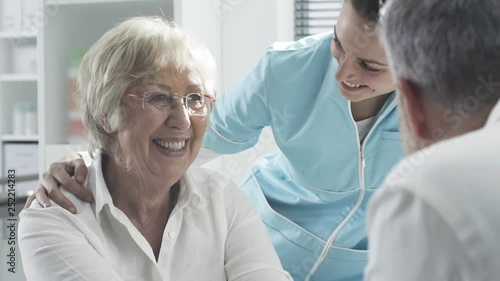 Medical staff supporting a senior patient photo