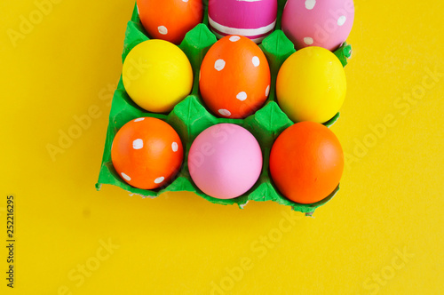 Easter eggs in a tray for eggs a stand. Yellow background.