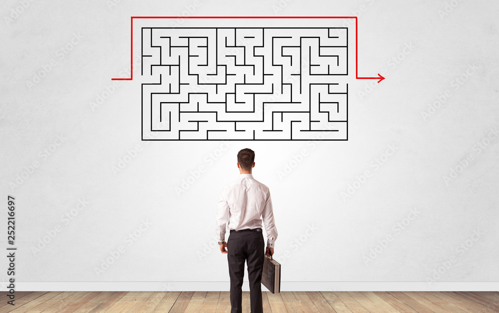 Businessman in doubt looking to a maze and searching the way out Businessman in doubt looking to a maze and searching the way out