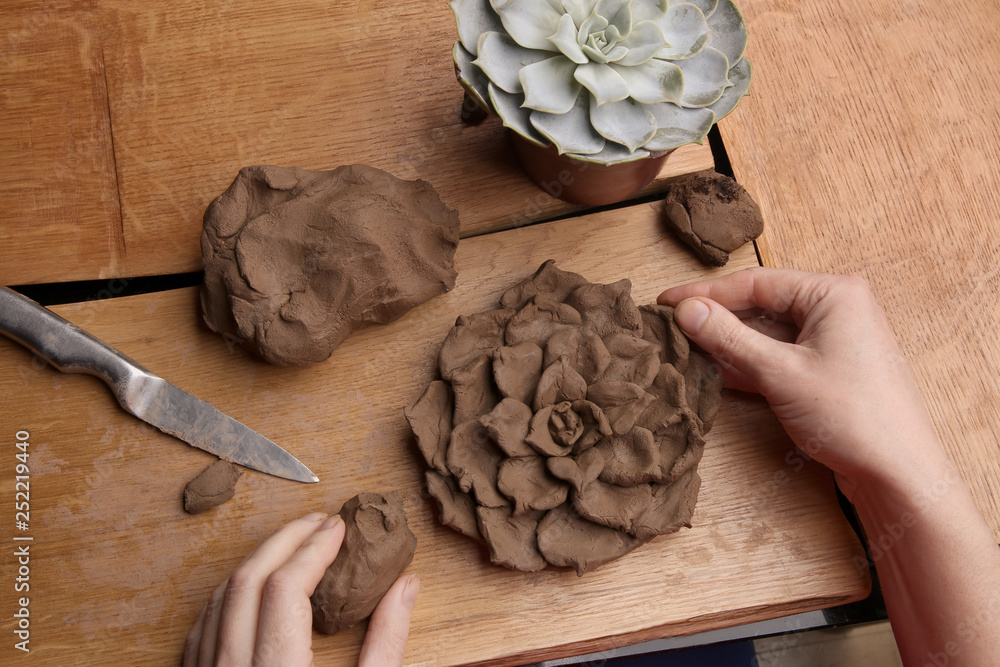 Closeup of hands sculpt clay plant decoration. Hands modeling crafts  pottery. Sculpting clay in the process. Stock Photo
