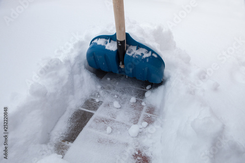 Cleaning snow with shovel in winter day 
