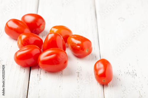 Cherry tomatoes on a white board background