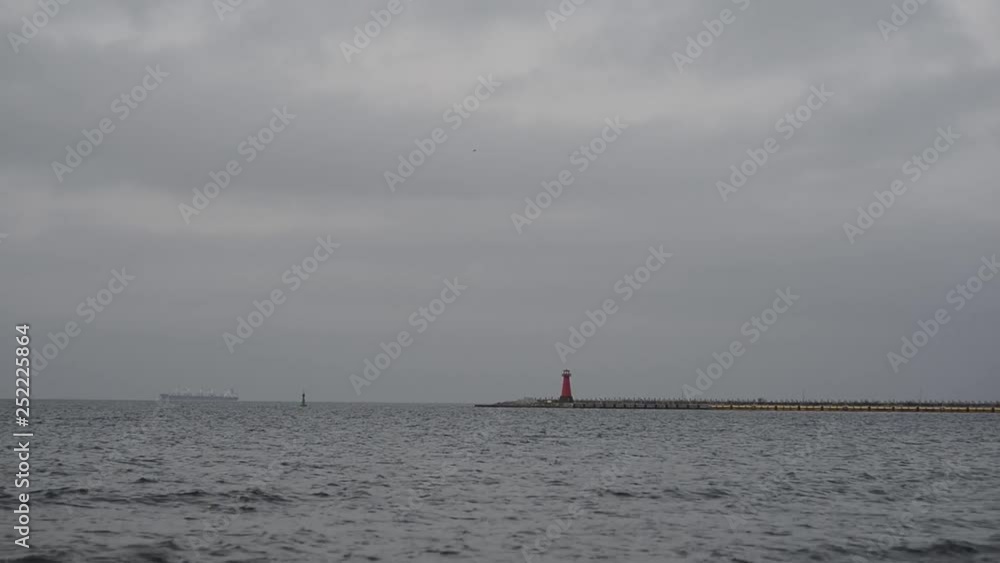 distant view of the lighthouse in the Baltic Sea. medium waves distant view of the lighthouse in the Baltic Sea. medium waves