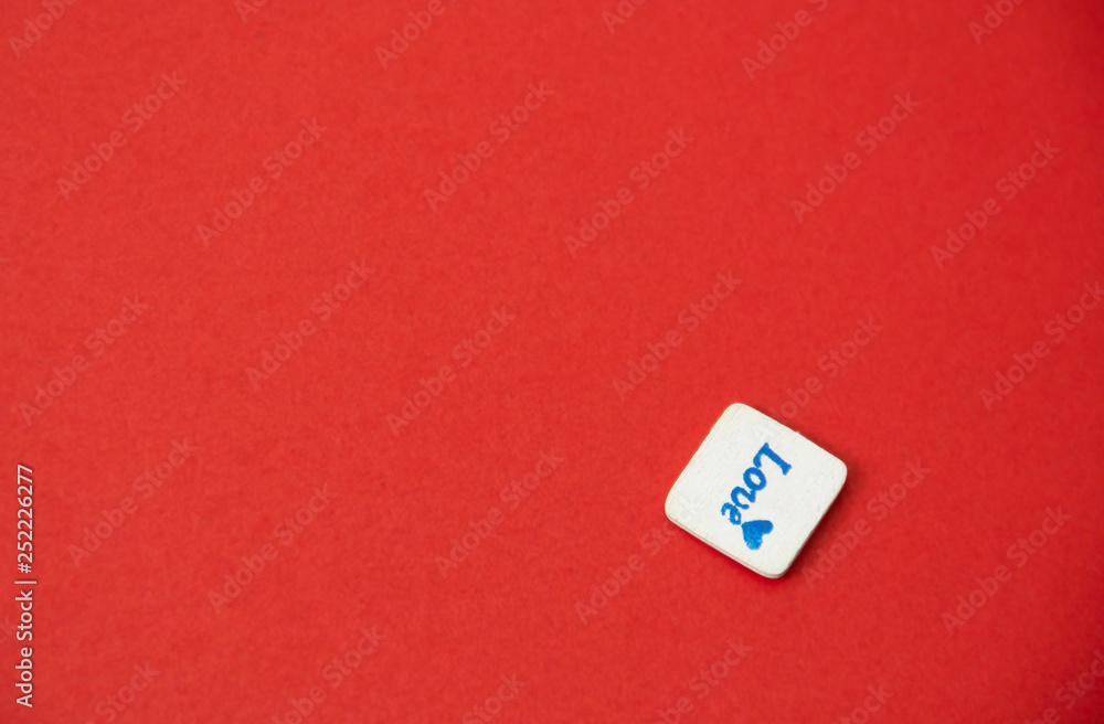 White square wood with love word written on red background, love concept. White square wood with love word written on red background, love concept.