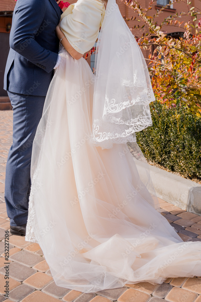 bride and groom stand together in the park in autumn bride and groom stand together in the park in autumn