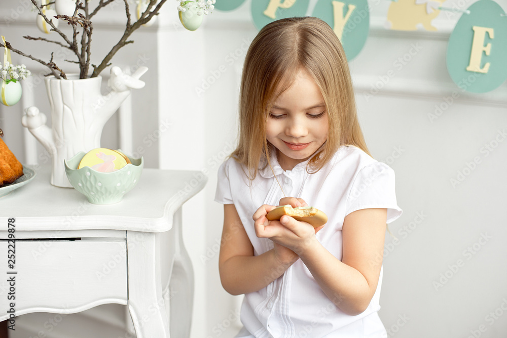 Cute toddler girl in a white shirt is eating with Easter eggs on Easter day. Cute toddler girl in a white shirt is eating with Easter eggs on Easter day.