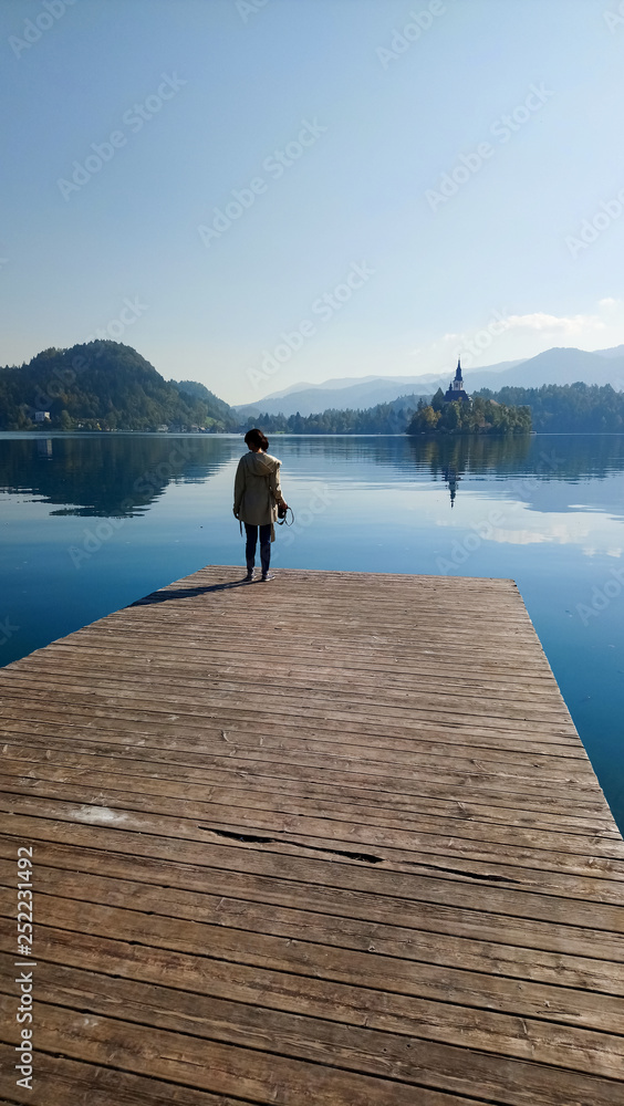 Girl  looking at lake Bled from wood bridge, Slovenia