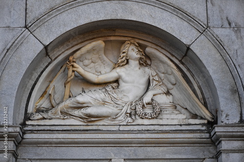 An old sandstone relief of resting angel with spread wings above a crypt in Berlin-Germany.