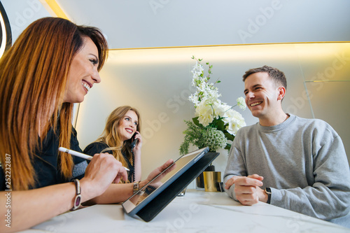 Female receptionists attending a patient at the modern reception of the clinic.