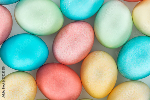 top view of pastel easter eggs on grey