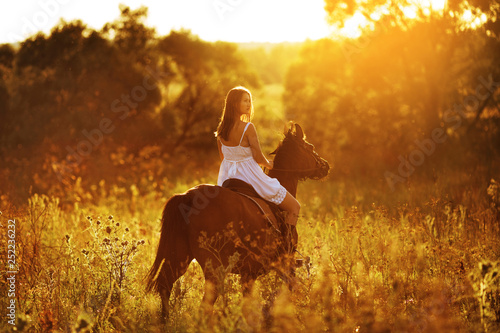 Girl in white dress riding a horse © dimedrol68