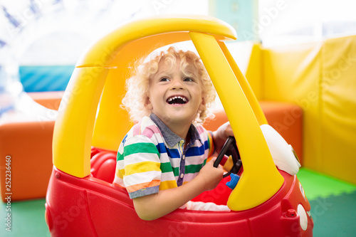 Child riding toy car. Little boy with toys.