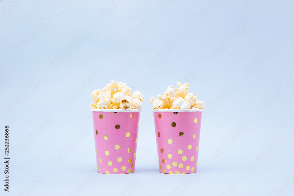 cup of tasty popcorn on a blue background cup of tasty popcorn on a blue background