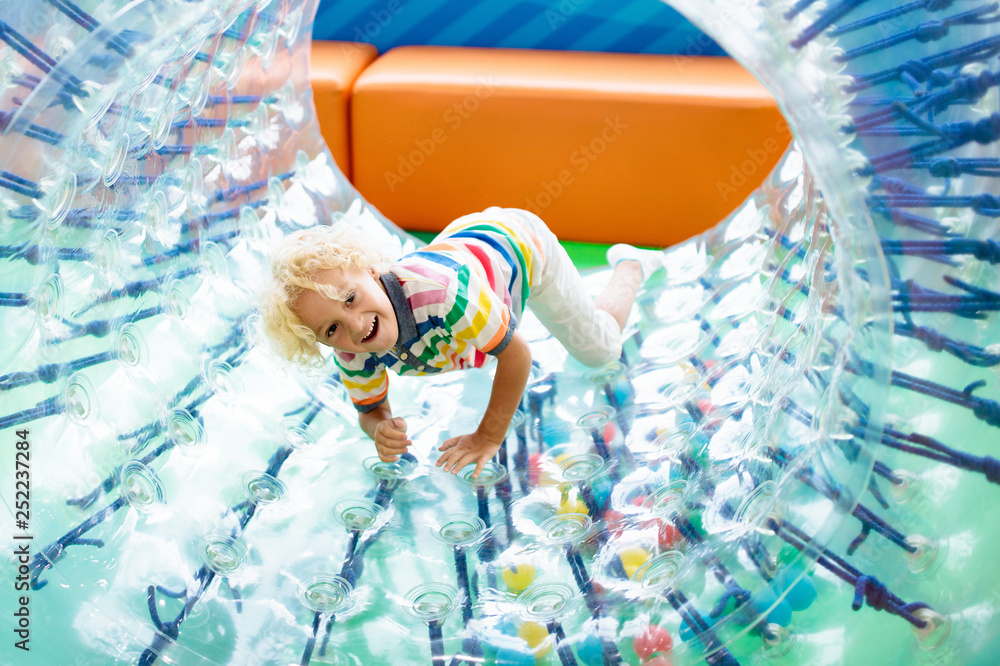 Fototapeta premium Child play in roller wheel. Kids on trampoline.