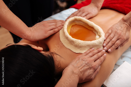 Woman having kati vasti Ayurveda treatment in salon