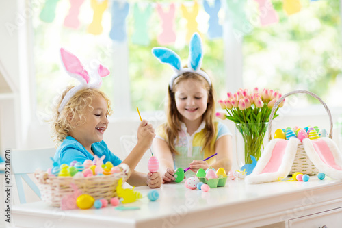Kids on Easter egg hunt. Children dye eggs.