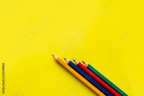 Multicolored pencils on a yellow background